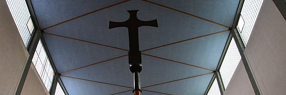 Blick zur Kirchendecke. Im Vordergrund ein Vortragekreuz